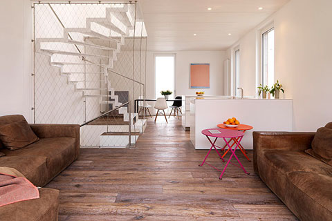 living room both sides brown leather sofas, in the background the white staircase