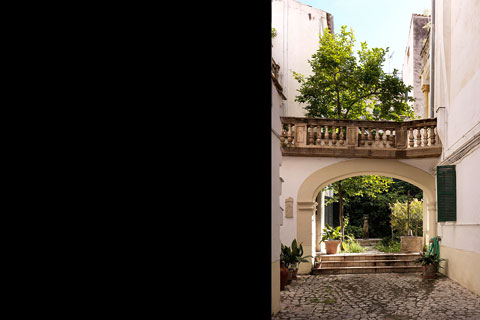 patio with cobblestone pavement, archway, view in garden