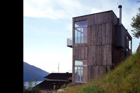 the sleek structure of paneled timber facade and the high-reaching windows